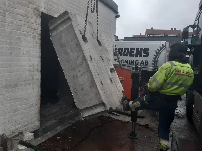 Utsågat betongblock lyfts bort vid en byggnad