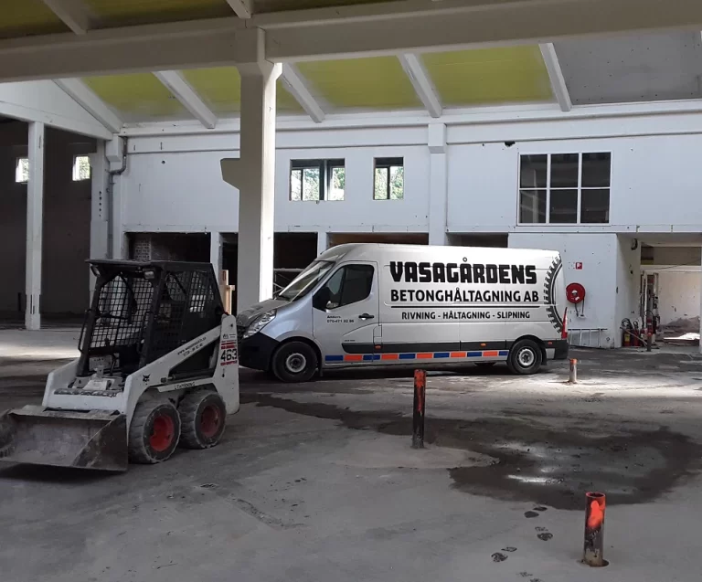 Vasagårdens servicebil och kompaktlastare i en industrilokal